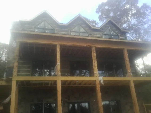 Dormers and porch framing on a large log home under construction — Roof Coating work by our crew in Ririe