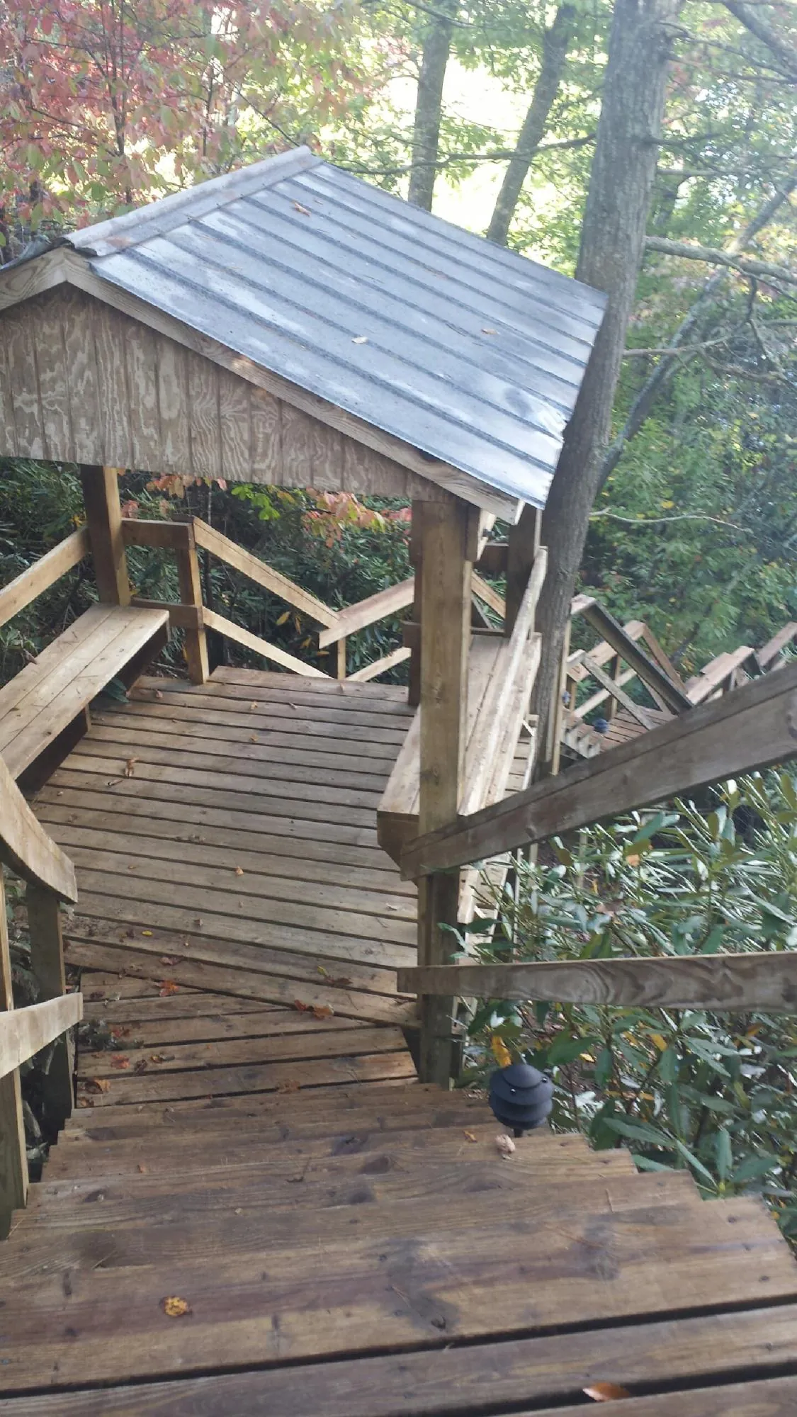 Metal roofed shelter over wooden steps on a wooded walkway — Skylight Repair & Installation work by our crew in Ririe